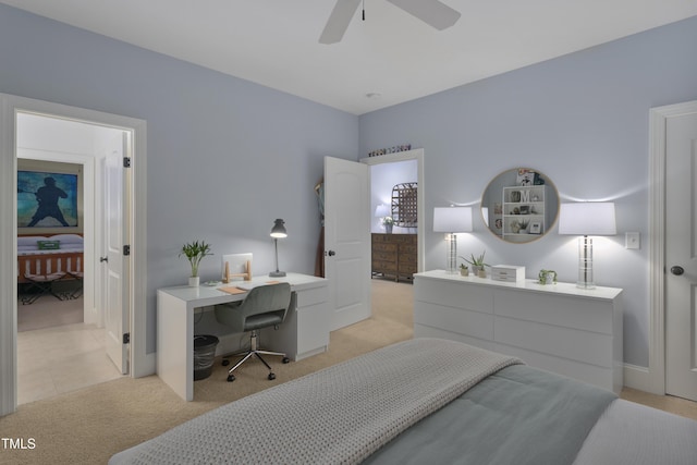 bedroom featuring light colored carpet, a ceiling fan, and baseboards