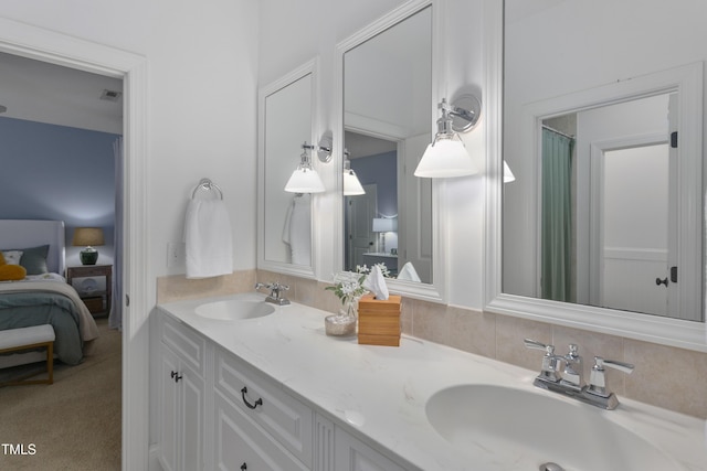 bathroom featuring double vanity, a sink, and connected bathroom