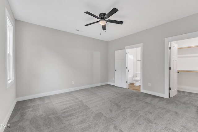 401 N Raiford St, Selma, NC 27576 - unfurnished bedroom featuring carpet floors, baseboards, a spacious closet, connected bathroom, and ceiling fan