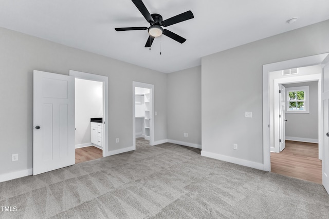 401 N Raiford St, Selma, NC 27576 - unfurnished bedroom featuring carpet flooring, a spacious closet, baseboards, connected bathroom, and a closet