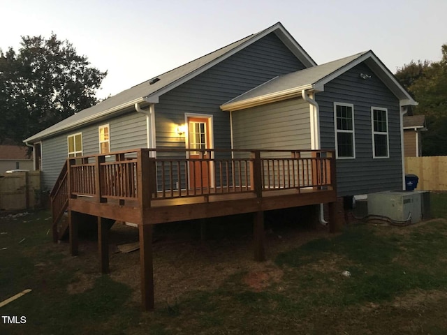 rear view of property featuring a wooden deck and central air condition unit