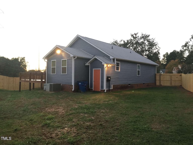 back of house with a wooden deck, crawl space, a fenced backyard, cooling unit, and a lawn
