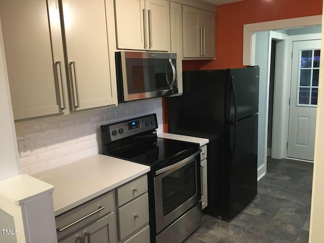 kitchen featuring gray cabinets, stainless steel appliances, light countertops, and decorative backsplash