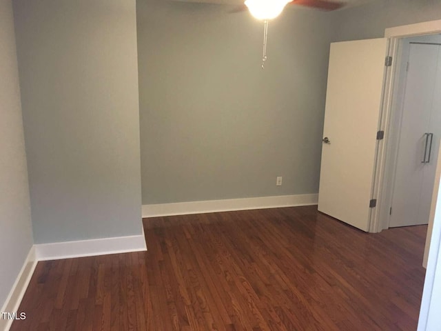 empty room with ceiling fan, wood finished floors, and baseboards
