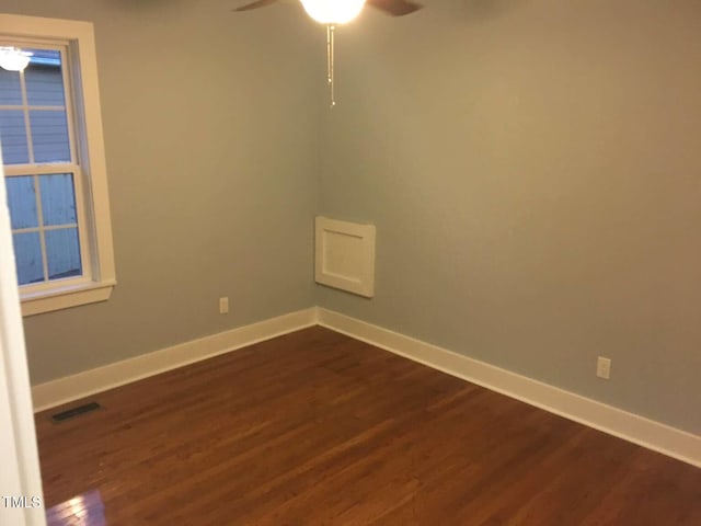 unfurnished room featuring dark wood-style floors, visible vents, ceiling fan, and baseboards