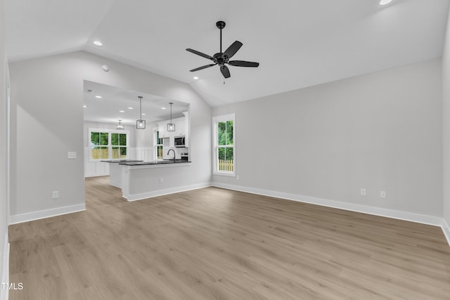405 N Raiford St, Selma, NC 27576 - unfurnished living room featuring vaulted ceiling, a sink, recessed lighting, a ceiling fan, and healthy amount of natural light
