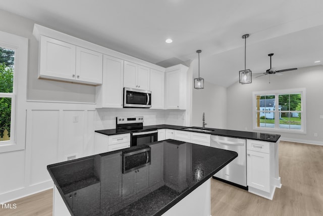 405 N Raiford St, Selma, NC 27576 - kitchen featuring appliances with stainless steel finishes, a sink, light wood-type flooring, a peninsula, and white cabinetry