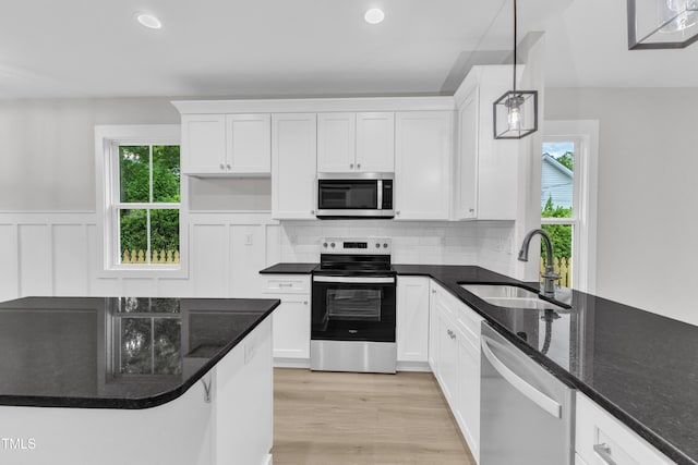 405 N Raiford St, Selma, NC 27576 - kitchen with stainless steel appliances, a sink, white cabinetry, recessed lighting, and wainscoting