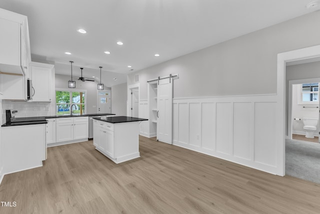 405 N Raiford St, Selma, NC 27576 - kitchen featuring a barn door, a ceiling fan, light wood finished floors, stainless steel appliances, and a center island