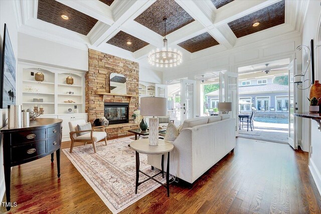 living area featuring plenty of natural light, a fireplace, coffered ceiling, and dark wood-style floors