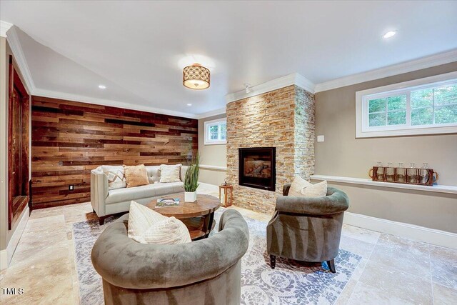 living room with baseboards, ornamental molding, recessed lighting, and a stone fireplace