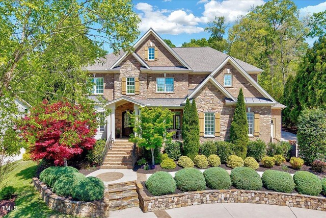 craftsman-style house featuring brick siding, stairway, and stone siding