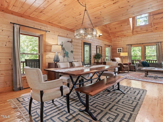 dining area featuring wooden walls, a healthy amount of sunlight, and light wood-style floors