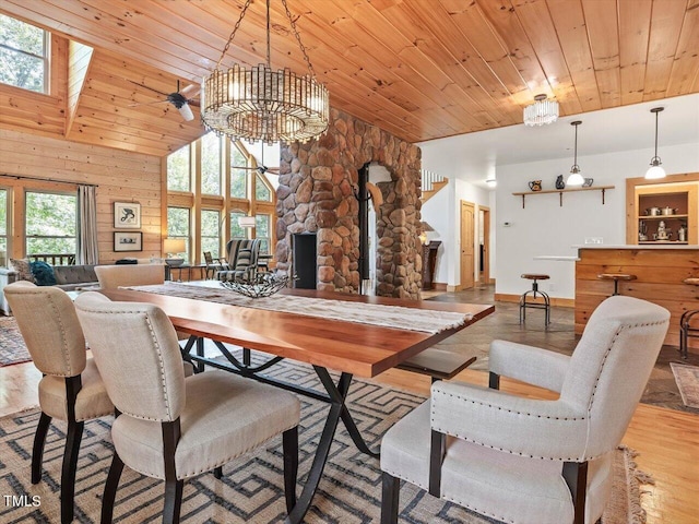 dining area with wood finished floors, baseboards, high vaulted ceiling, a chandelier, and wooden ceiling