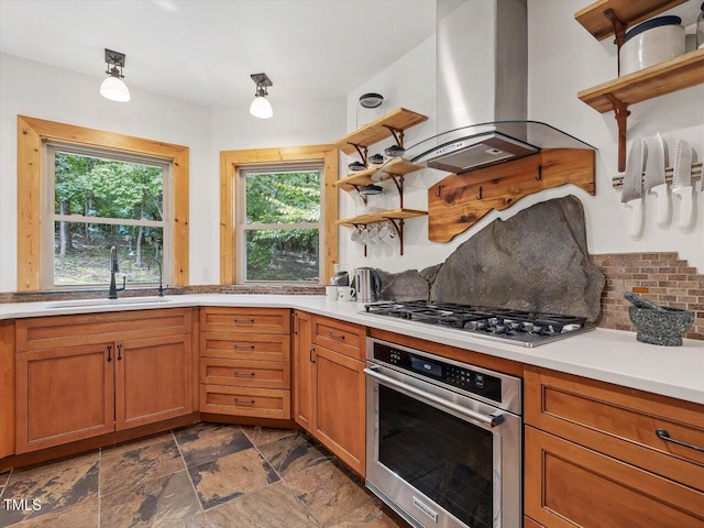 kitchen featuring open shelves, a sink, stainless steel appliances, decorative backsplash, and island range hood