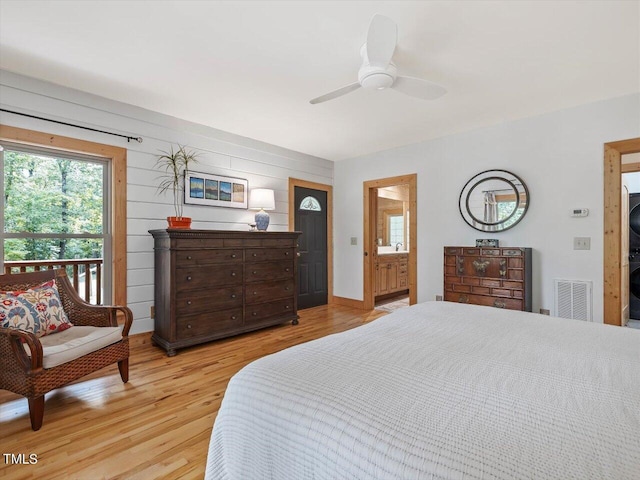 bedroom with ceiling fan, visible vents, ensuite bathroom, and light wood-type flooring