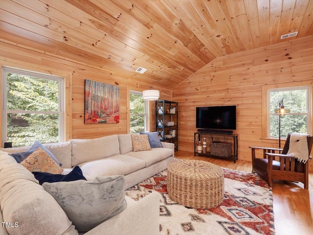 living area featuring wood ceiling, visible vents, wood finished floors, lofted ceiling, and wooden walls