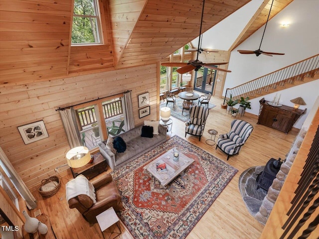 living area featuring ceiling fan, wood finished floors, a healthy amount of sunlight, and high vaulted ceiling