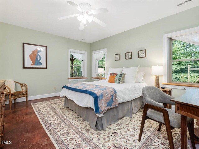 bedroom with baseboards, multiple windows, concrete flooring, and visible vents