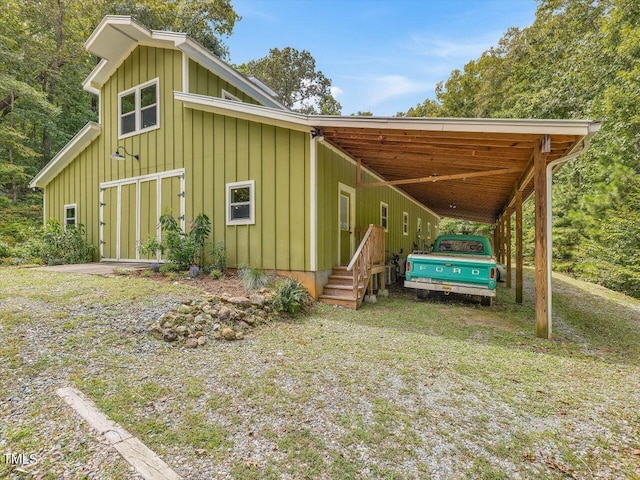 exterior space with board and batten siding and an attached carport
