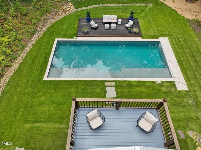 pool with an outdoor living space, a yard, and a deck