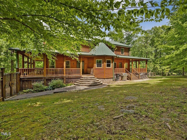 rear view of house with a porch and a lawn