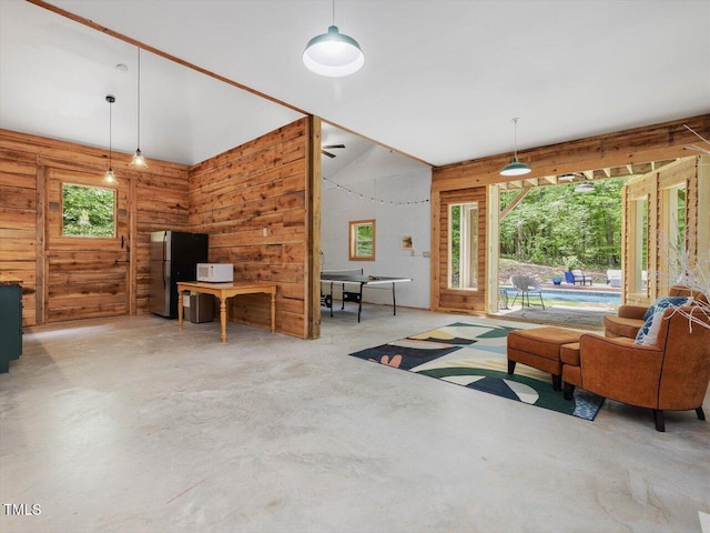 living room featuring wooden walls and concrete flooring