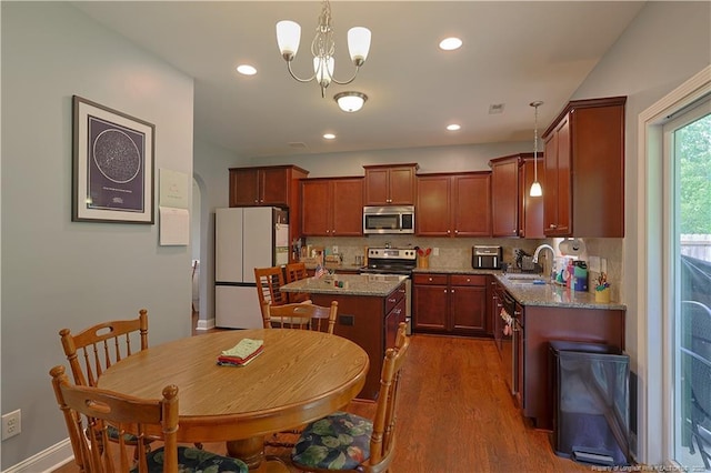 508 Stonebriar Ave, Raeford, NC 28376 - kitchen featuring appliances with stainless steel finishes, a sink, dark wood finished floors, tasteful backsplash, and a kitchen island