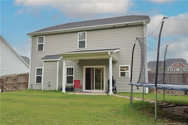 rear view of property featuring a trampoline