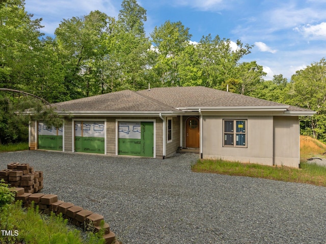 view of front of house featuring a shingled roof and driveway