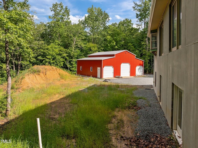 view of yard featuring a garage and an outbuilding