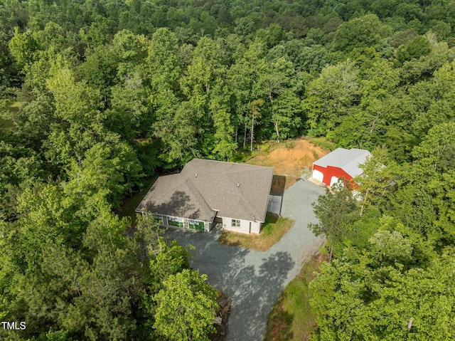 aerial view of property and surrounding area with a heavily wooded area