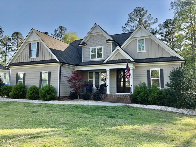 175 Lockamy Ln, Youngsville, NC 27596 - craftsman-style home featuring board and batten siding, a porch, a front yard, and roof with shingles