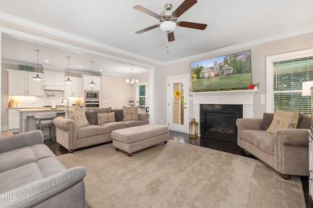 175 Lockamy Ln, Youngsville, NC 27596 - living room featuring crown molding, a glass covered fireplace, a ceiling fan, dark wood-style floors, and a chandelier