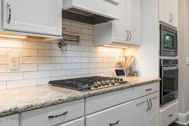175 Lockamy Ln, Youngsville, NC 27596 - kitchen featuring appliances with stainless steel finishes, white cabinets, backsplash, custom exhaust hood, and light stone countertops