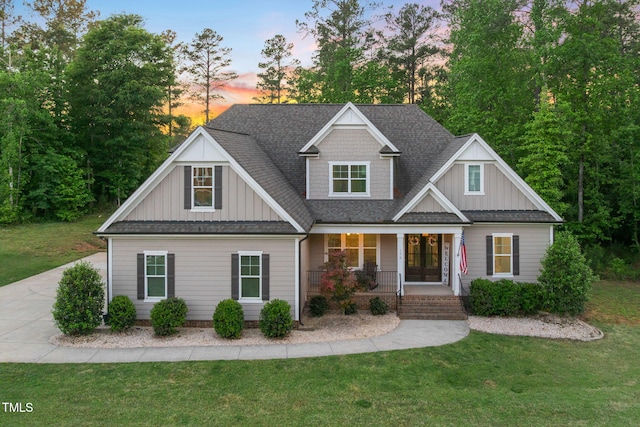 175 Lockamy Ln, Youngsville, NC 27596 - view of front facade with board and batten siding, a porch, a yard, and roof with shingles