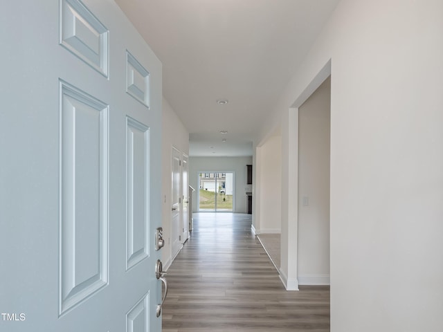 hallway featuring baseboards and wood finished floors