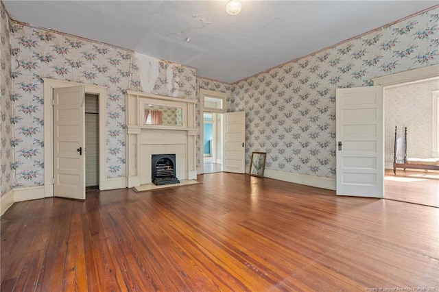 205 N Vance St, Pembroke, NC 28377 - unfurnished living room featuring a fireplace with flush hearth, hardwood / wood-style flooring, wallpapered walls, and baseboards