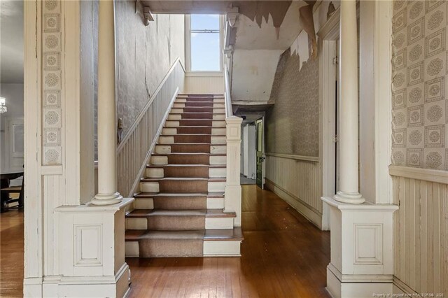 205 N Vance St, Pembroke, NC 28377 - stairs featuring hardwood / wood-style floors, wallpapered walls, and wainscoting
