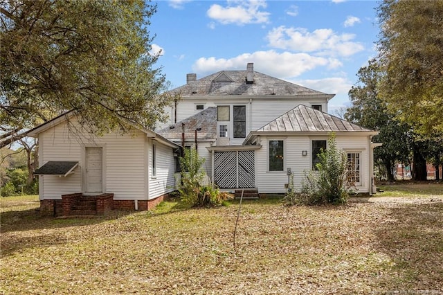 205 N Vance St, Pembroke, NC 28377 - rear view of house with a chimney, entry steps, and a standing seam roof