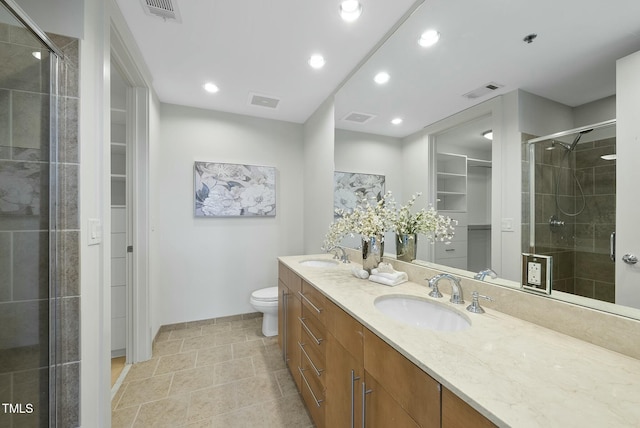 bathroom featuring a stall shower, a sink, a spacious closet, and visible vents