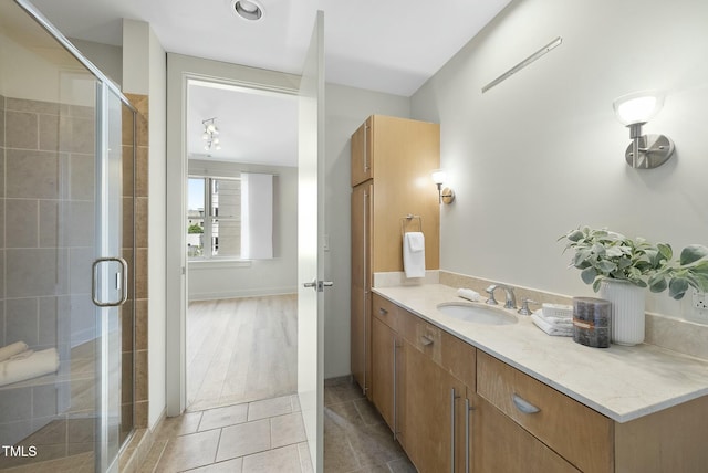 bathroom with a stall shower, tile patterned floors, and vanity