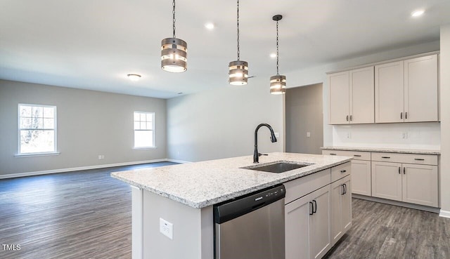 kitchen with a sink, a center island with sink, dark wood-type flooring, pendant lighting, and dishwasher