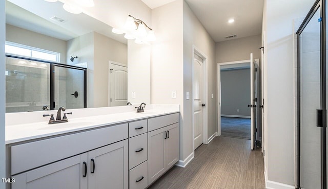 full bathroom with visible vents, a shower stall, baseboards, and a sink
