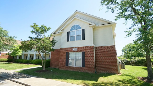4024 Claret Ln, Morrisville, NC 27560 - view of side of property featuring a yard, brick siding, and central air condition unit