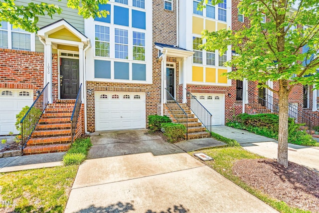 view of front of home featuring an attached garage, concrete driveway, and brick siding