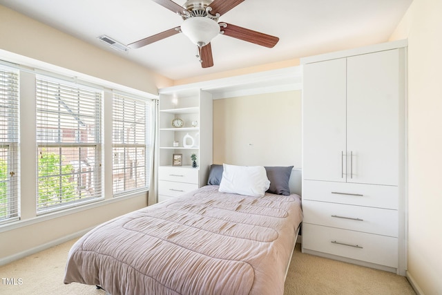 bedroom featuring light carpet, multiple windows, baseboards, and a ceiling fan
