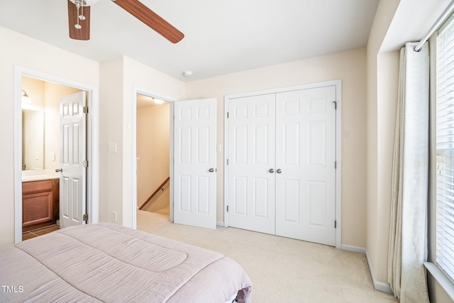 bedroom with light carpet, a closet, ceiling fan, and baseboards