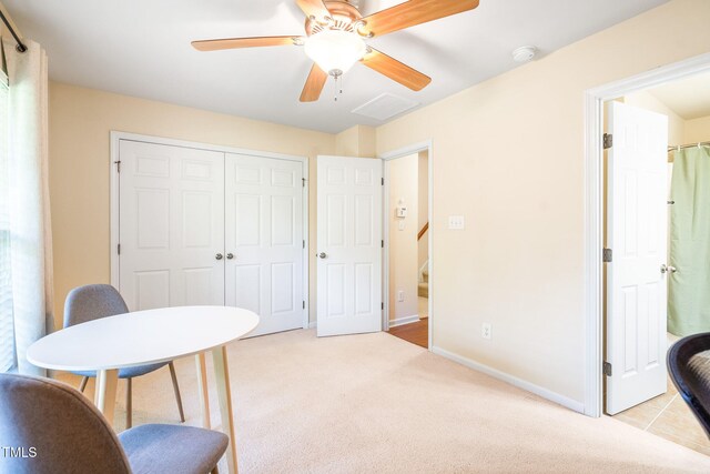 office featuring ceiling fan, light carpet, and baseboards