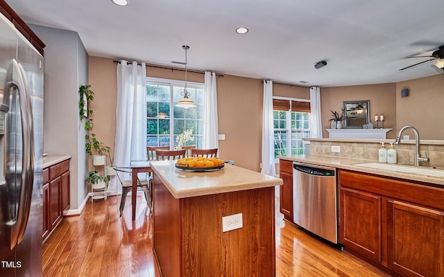 5031 Mckittrick Ln, Durham, NC 27712 - kitchen with appliances with stainless steel finishes, light wood finished floors, light countertops, a center island, and recessed lighting